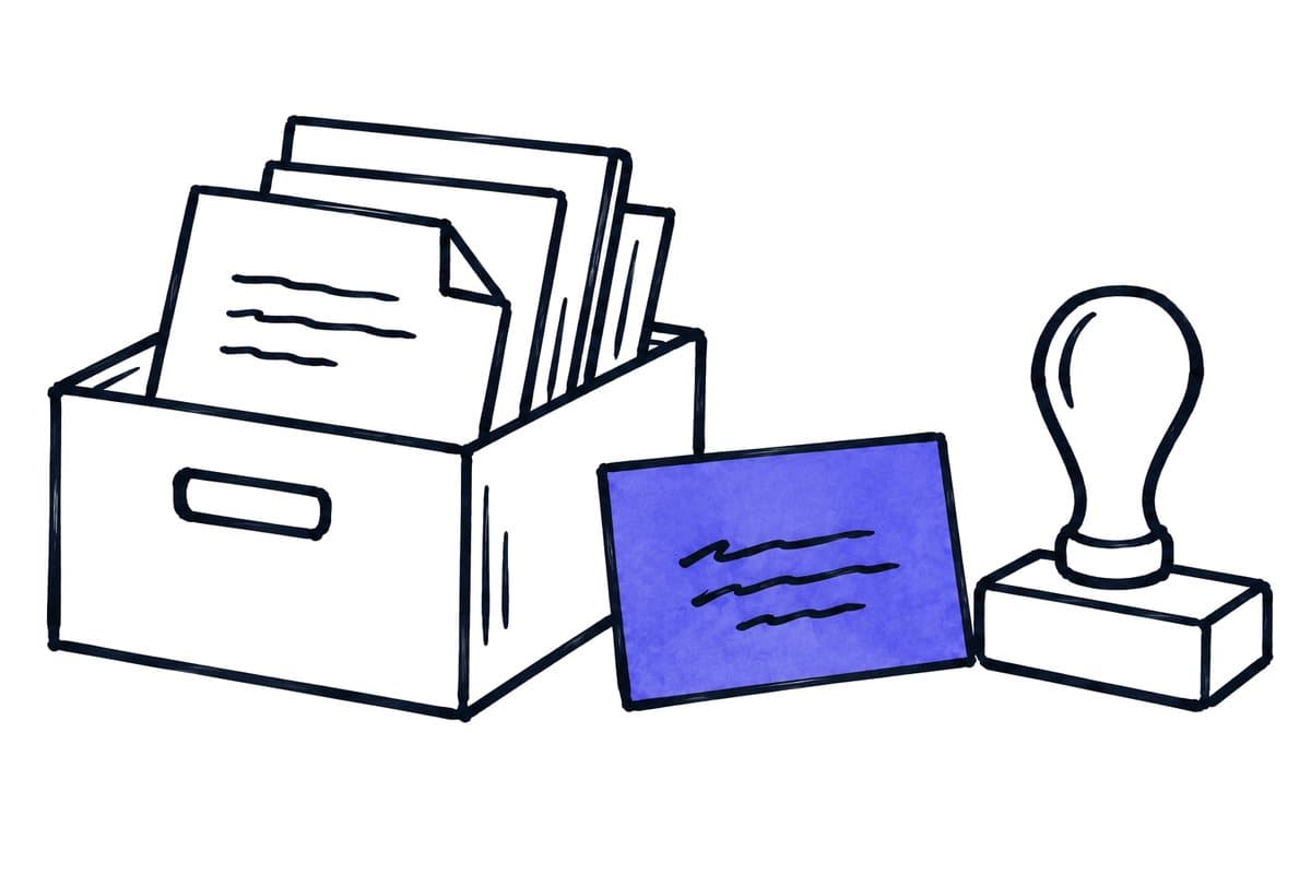 a box of documents, a card and a rubber stamp side by side